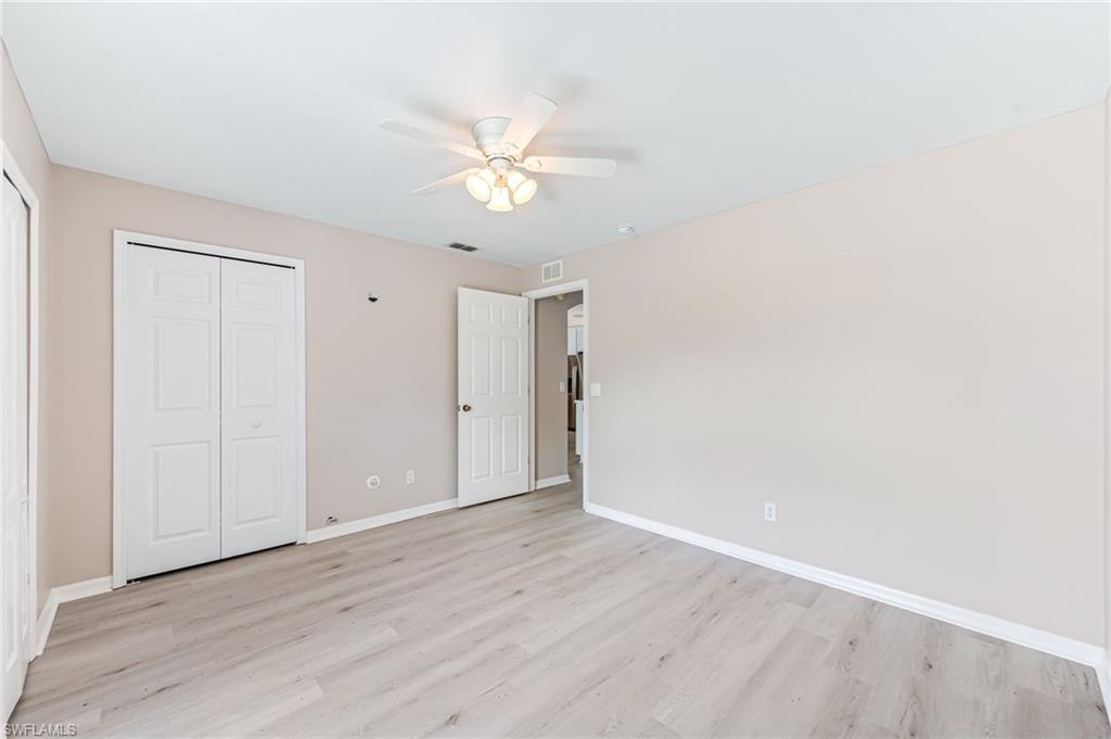 3630 10th Avenue Southeast Naples, FL 34117 - Photo 34 of 50 an empty room with wooden floor and fan