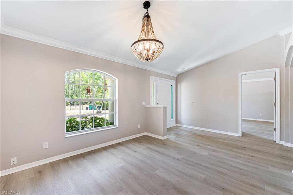 3630 10th Avenue Southeast Naples, FL 34117 - Photo 6 of 50 an empty room with wooden floor cabinet and windows