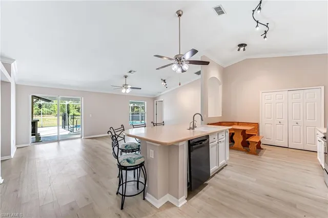 a kitchen with stainless steel appliances granite countertop a stove and chairs with wooden floor