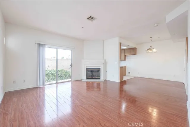 an empty room with wooden floor and fireplace