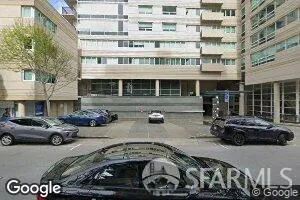 a front view of a building with cars parked