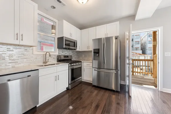 a kitchen with stainless steel appliances a refrigerator sink and microwave