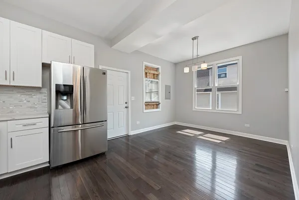 a kitchen with stainless steel appliances wooden floor and a window