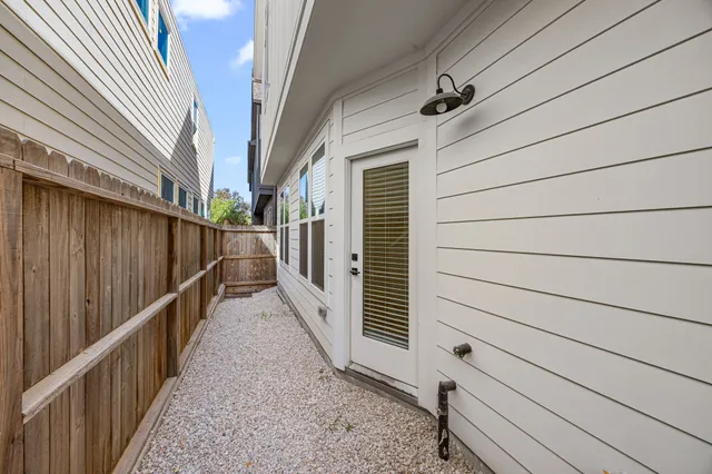 a view of a pathway of a house with wooden fence