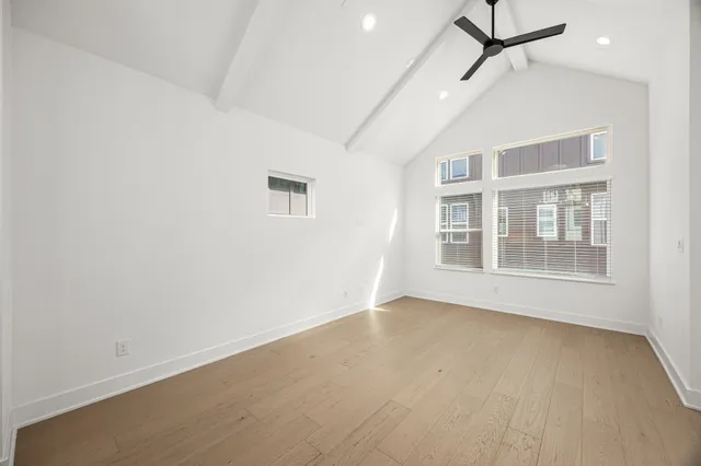 a view of empty room with wooden floor and windows
