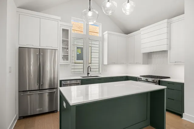 a kitchen with stainless steel appliances granite countertop a stove and a refrigerator