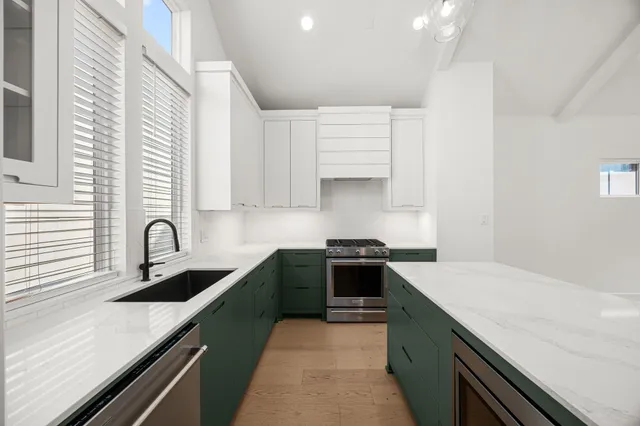 a kitchen with a sink a refrigerator and a stove top oven