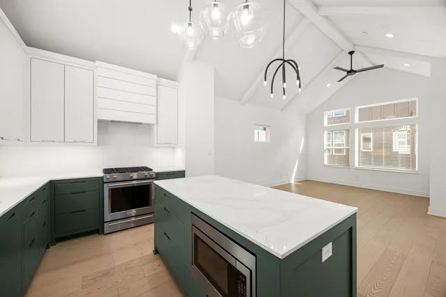 a kitchen with granite countertop a sink a stove and cabinets