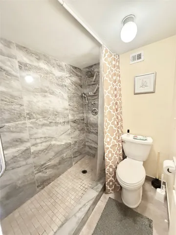 a bathroom with a toilet and a shower