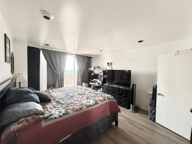 a bedroom with a bed flat screen tv and a refrigerator