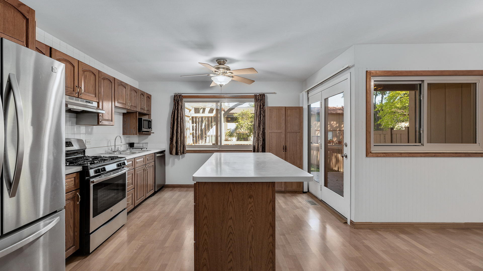 792 Oregon Trail Roselle, IL 60172 - Photo 4 of 19 a kitchen with stainless steel appliances granite countertop a refrigerator a stove a sink dishwasher and a refrigerator with wooden floor