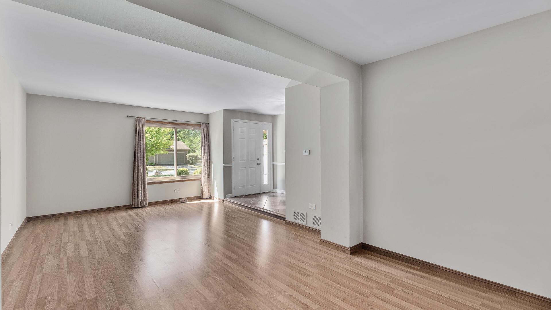 792 Oregon Trail Roselle, IL 60172 - Photo 6 of 19 a view of an empty room with wooden floor and a window
