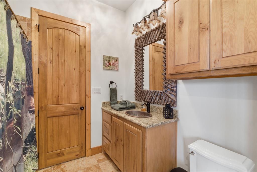 735 Gresham Lane Jacksboro, TX 76458 - Photo 18 of 40 a bathroom with a granite countertop sink and a washing machine