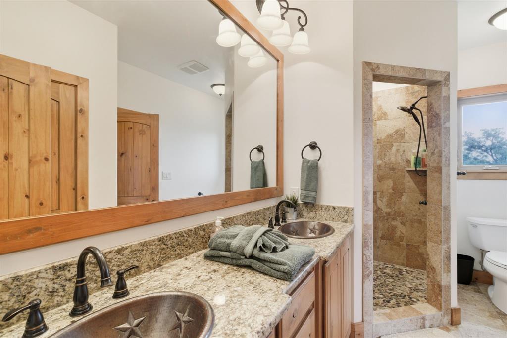 735 Gresham Lane Jacksboro, TX 76458 - Photo 22 of 40 a bathroom with a granite countertop sink and a mirror