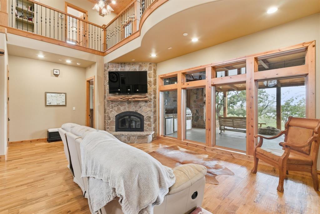 735 Gresham Lane Jacksboro, TX 76458 - Photo 10 of 40 a large bedroom with a large bed a flat tv screen and a fireplace