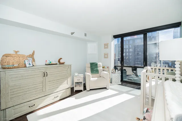 a bedroom with furniture and a large window