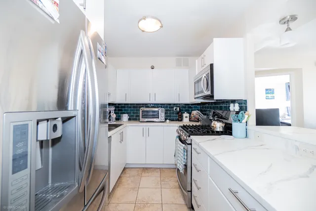 a kitchen with a sink a refrigerator and cabinets