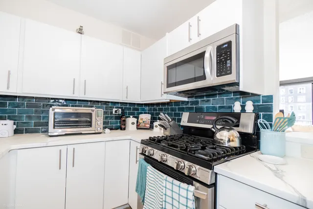 a kitchen with stainless steel appliances a stove a microwave and sink