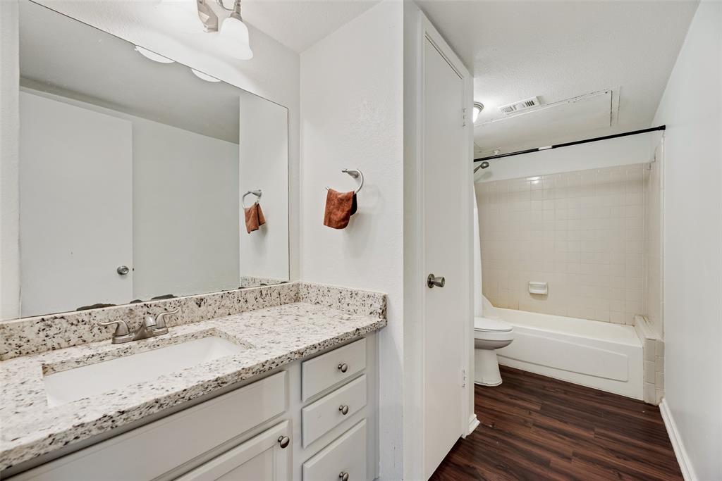 449 Harris Street, Unit 101L Coppell, TX 75019 - Photo 17 of 22 a bathroom with a granite countertop sink toilet and shower