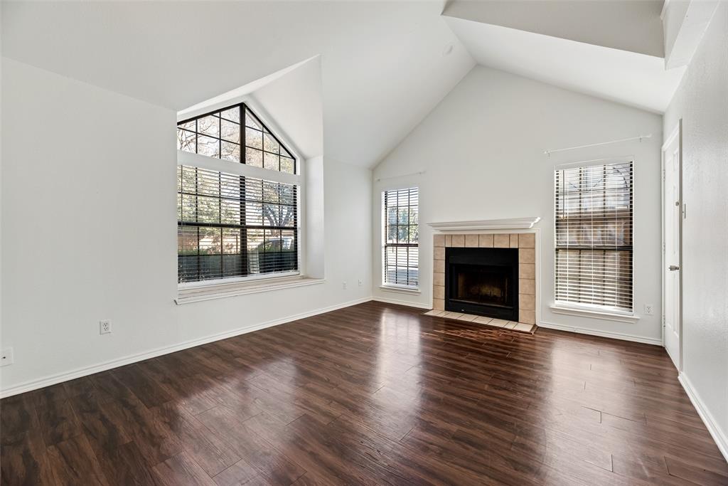 449 Harris Street, Unit 101L Coppell, TX 75019 - Photo 4 of 22 an empty room with wooden floor fireplace and windows