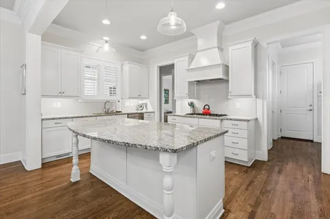 a kitchen with stainless steel appliances granite countertop a sink stove and wooden floor