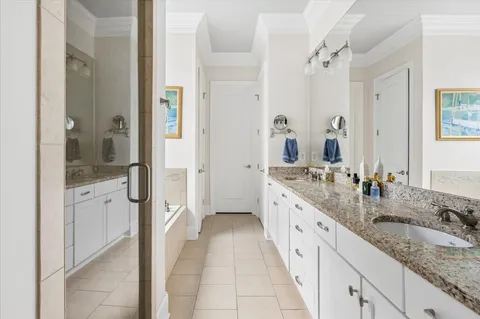 a large white bathroom with a granite countertop sink mirror and shower
