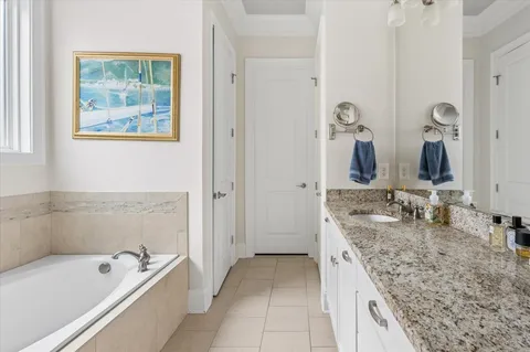 a bathroom with a granite countertop tub sink and mirror