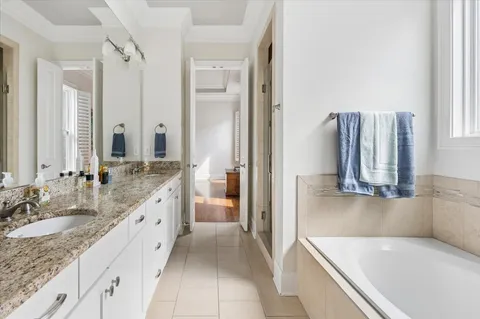 a bathroom with a granite countertop tub sink and mirror