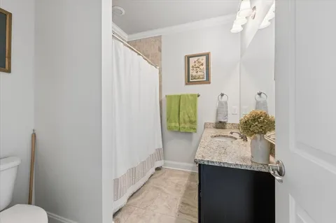 a bathroom with a granite countertop sink and a toilet