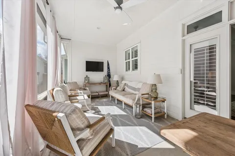 a living room with furniture a flat screen tv and a window