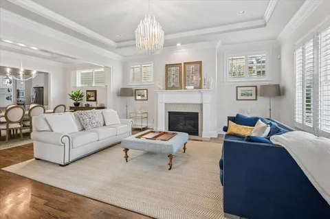 a living room with furniture a chandelier and a fireplace