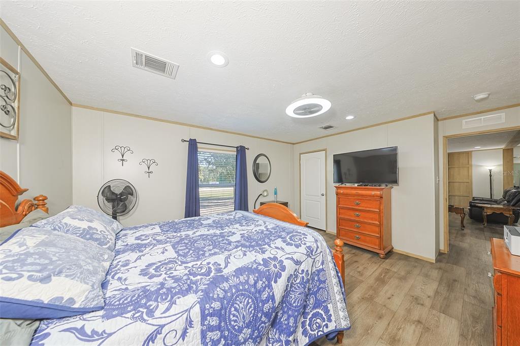 12124 Redrose Avenue Weeki Wachee, FL 34614 - Photo 23 of 57 a bedroom with a large bed and a flat tv screen