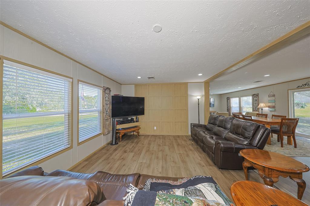 12124 Redrose Avenue Weeki Wachee, FL 34614 - Photo 27 of 57 a living room with furniture and a flat screen tv