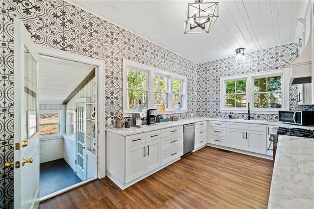 a kitchen with stainless steel appliances sink cabinets and wooden floor