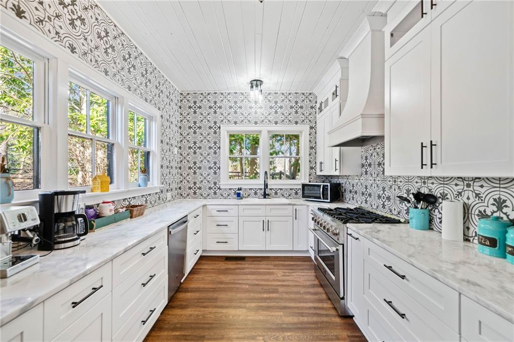 634 South Main Street Jasper, GA 30143 - Photo 17 of 39 a large white kitchen with stainless steel appliances granite countertop a stove a sink dishwasher and white cabinets with wooden floor