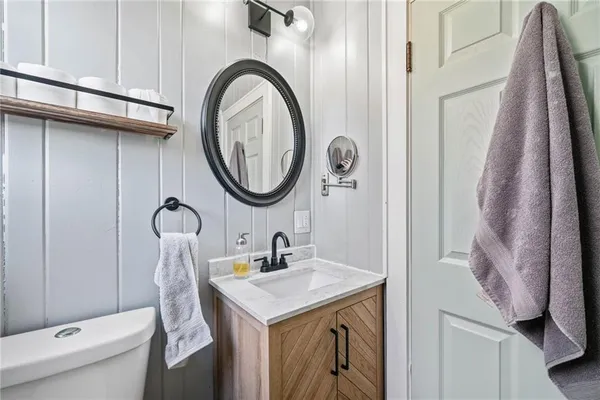 a bathroom with a sink a toilet and a mirror