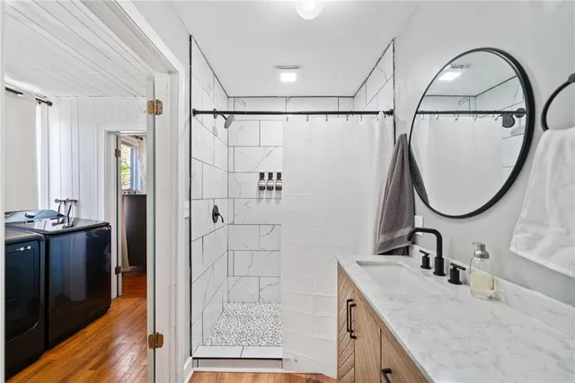 a bathroom with a granite countertop sink a mirror and a shower