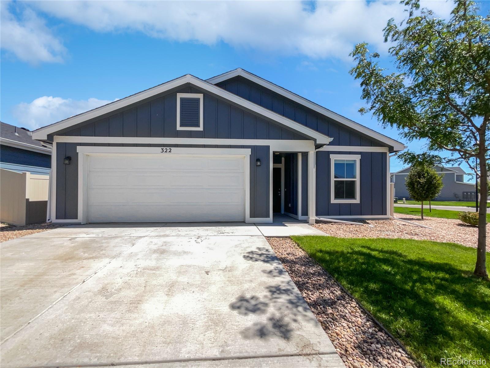 a front view of a house with yard and green space