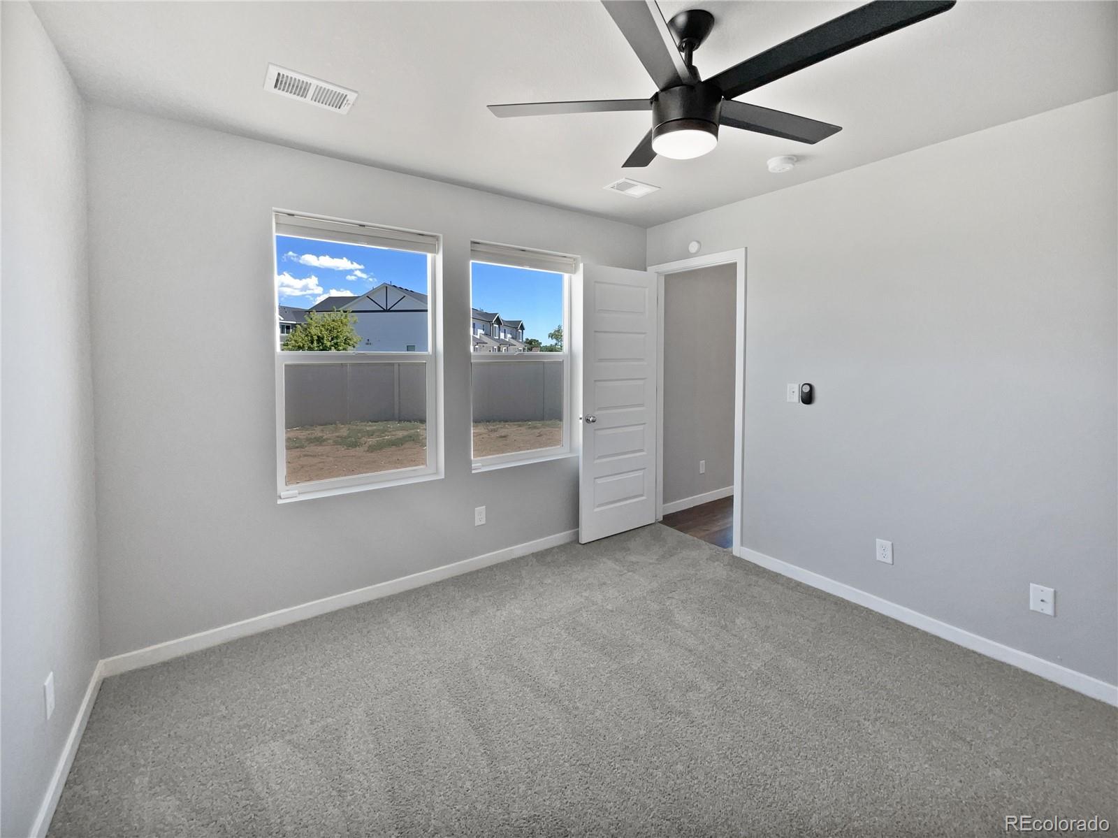 322 Bozeman Trail Ault, CO 80610 - Photo 17 of 19 an empty room with windows and fan