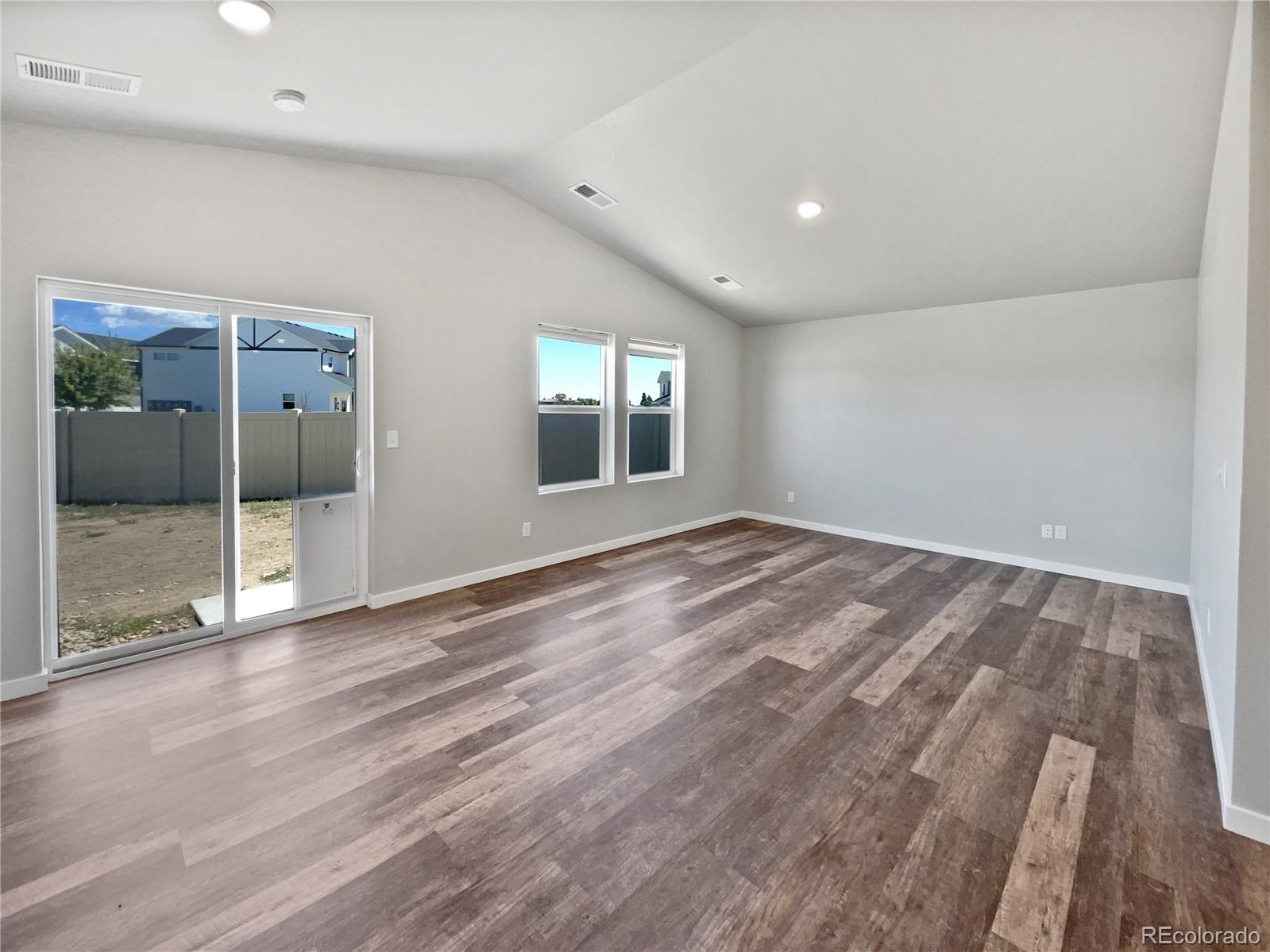 322 Bozeman Trail Ault, CO 80610 - Photo 3 of 19 an empty room with wooden floor and windows