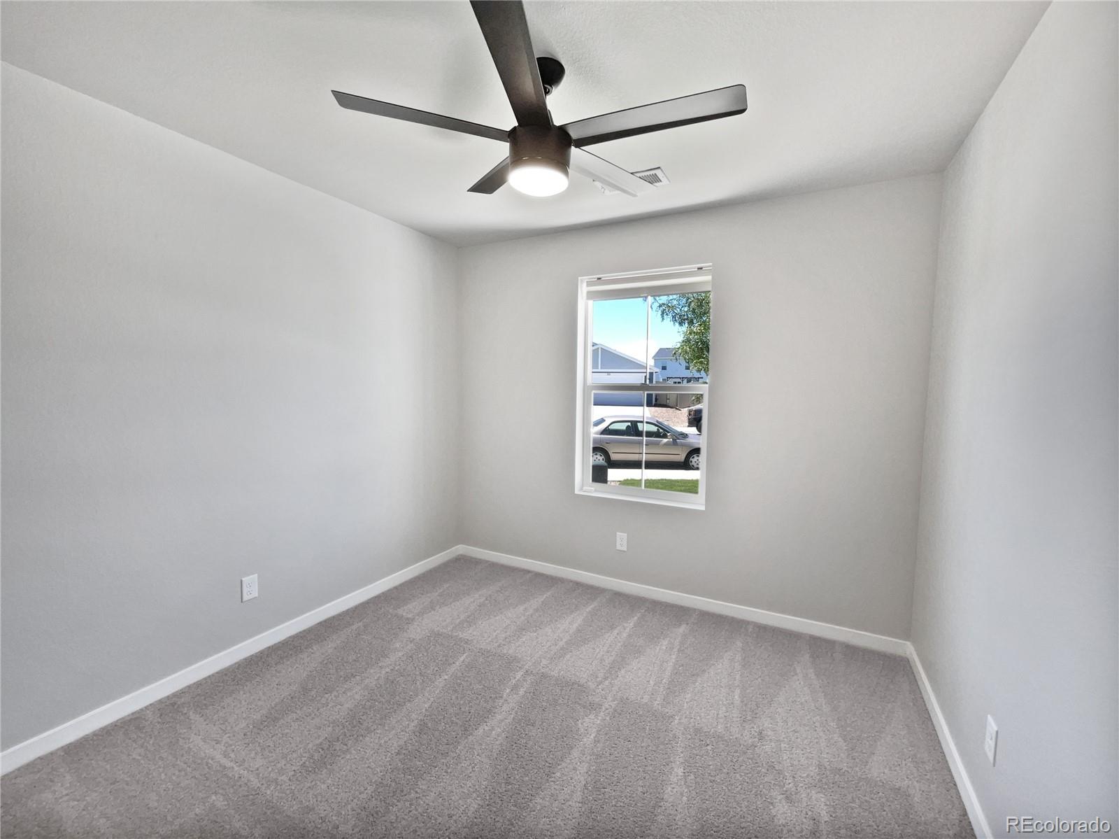 322 Bozeman Trail Ault, CO 80610 - Photo 8 of 19 an empty room with window and ceiling fan