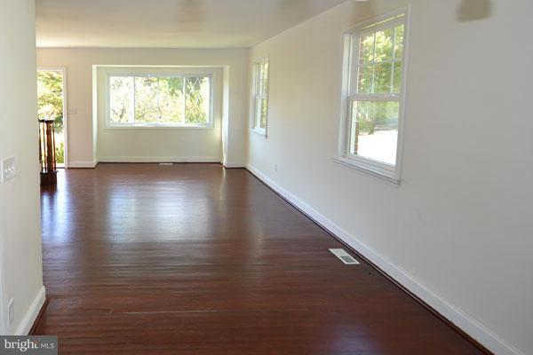 4405 Wakefield Road Baltimore, MD 21216 - Photo 3 of 17 an empty room with wooden floor and windows