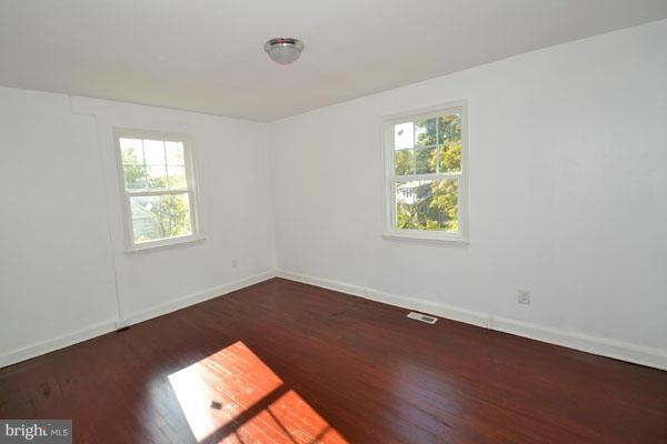 4405 Wakefield Road Baltimore, MD 21216 - Photo 5 of 17 an empty room with wooden floor and windows