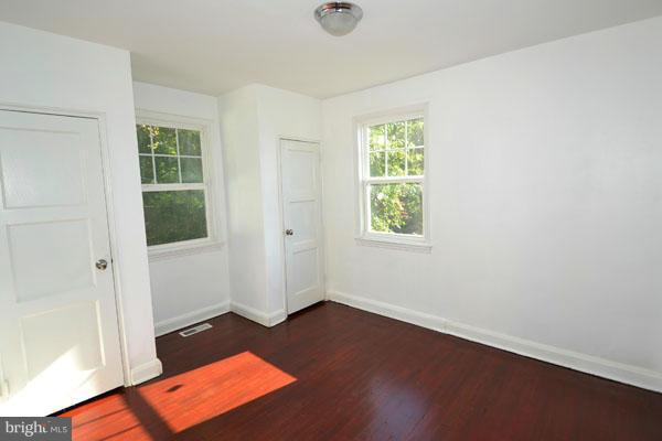 4405 Wakefield Road Baltimore, MD 21216 - Photo 6 of 17 an empty room with wooden floor and windows