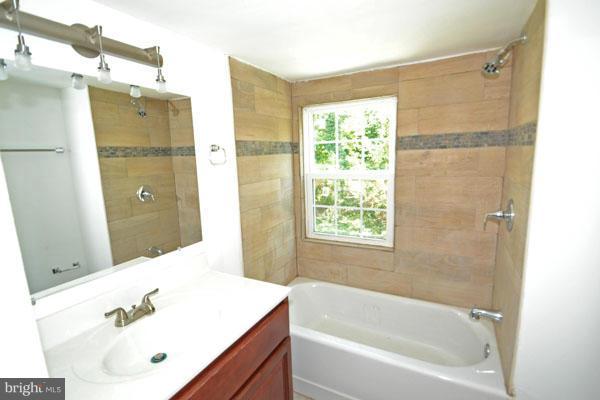 4405 Wakefield Road Baltimore, MD 21216 - Photo 10 of 17 a bathroom with a tub sink shower and mirror
