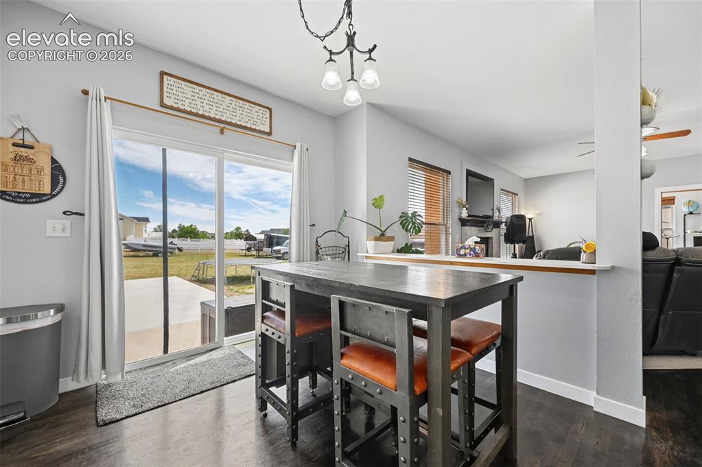 8347 Tibbs Road Peyton, CO 80831 - Photo 25 of 39 Dining area featuring dark wood-finish flooring and a contemporary pendant light fixture