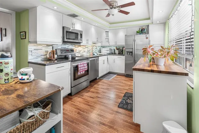 a kitchen with stainless steel appliances kitchen island granite countertop a stove a sink and a microwave