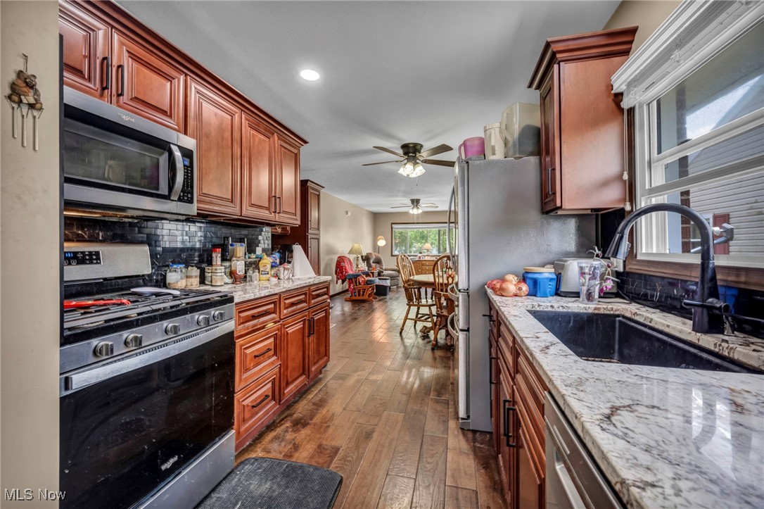 146 Hillman Road Akron, OH 44312 - Photo 23 of 49 Kitchen featuring appliances with stainless steel finishes, a sink, ceiling fan, dark wood-style floors, and backsplash