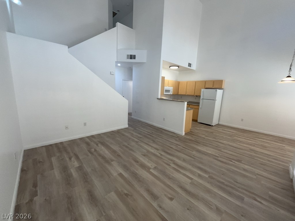 4915 East Russell Road, Unit 144 Las Vegas, NV 89120 - Photo 3 of 14 Unfurnished living room with light wood-style floors and a high ceiling