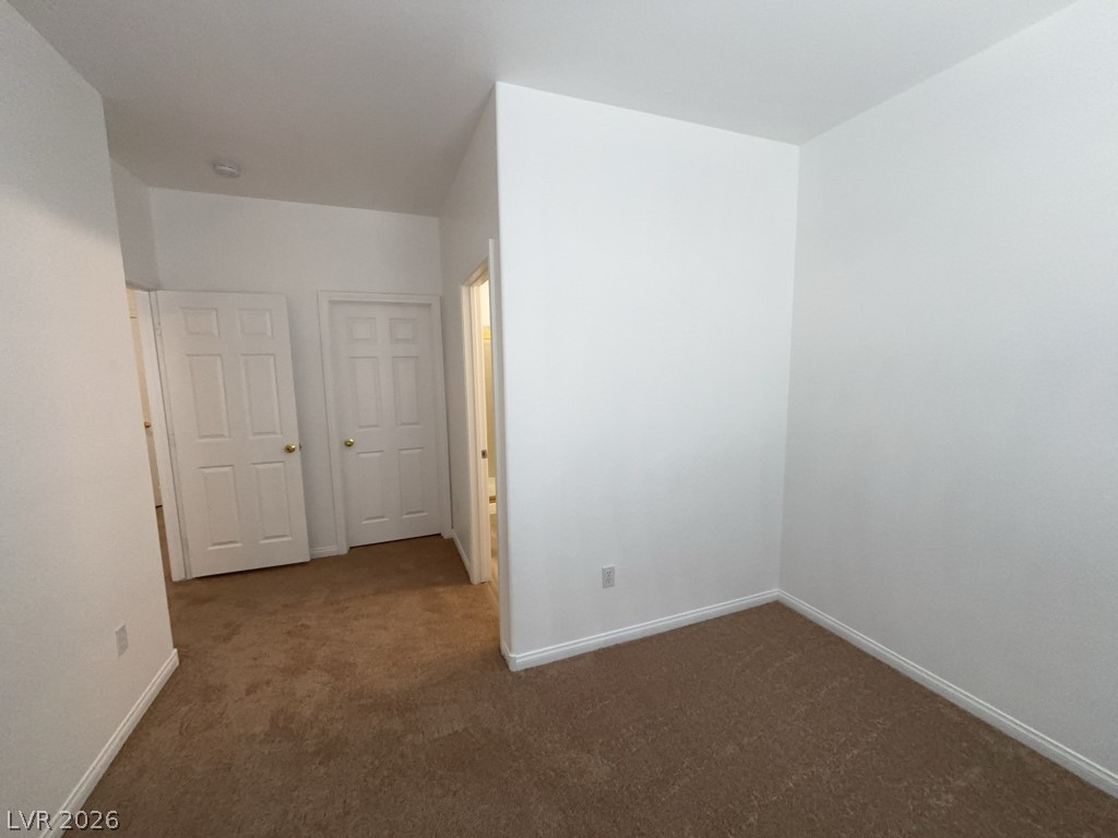4915 East Russell Road, Unit 144 Las Vegas, NV 89120 - Photo 9 of 14 Unfurnished room featuring baseboards and dark colored carpet